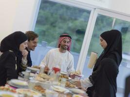 eid mubarak musulmano famiglia avendo iftar cena potabile acqua per rompere festa. mangiare tradizionale cibo durante Ramadan banchettare mese a casa. il islamico halal mangiare e potabile a moderno occidentale isla foto