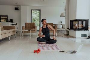 giovane bellissimo femmina esercizio, allungamento e praticando yoga con allenatore attraverso video chiamata conferenza nel luminosa soleggiato Casa. salutare stile di vita, benessere e consapevolezza concetto. foto