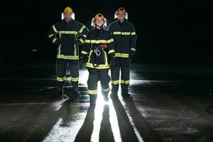 ritratto di un' gruppo di i vigili del fuoco in piedi e a piedi coraggioso e ottimista con un' femmina come squadra capo. foto