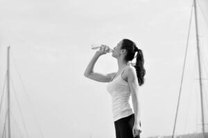 acqua potabile della giovane bella donna dopo l'esercizio di forma fisica foto