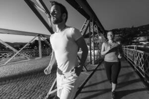 coppia che fa jogging attraverso il ponte della città foto