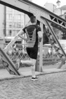 uomo che fa jogging attraverso il ponte della città foto