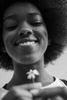 ritratto di ragazza afroamericana con un fiore in mano foto