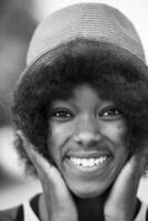 primo piano ritratto di una bella giovane donna afroamericana sorridente e alzando lo sguardo foto