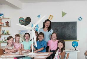 elementare scuola stelo robotica aula diverso gruppo di bambini edificio e programmazione mulino a vento ecologia robot concetto. insieme parlando e Lavorando come un' squadra. creativo robotica ingegneria foto