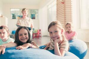 lettura tempo nel elementare scuola o asilo, insegnante lettura un' libro per bambini nel elementare scuola o asilo nido. selettivo messa a fuoco foto