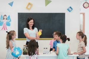 femmina insegnante con bambini nel geografia classe guardare a globo. lato Visualizza di gruppo di diverso contento scuola bambini con globo nel aula a scuola. foto