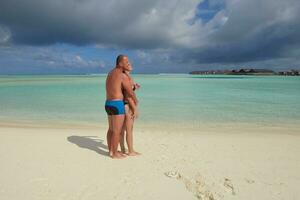 la giovane coppia felice si diverte sulla spiaggia foto