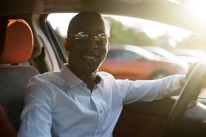 felice afroamericano alla guida di un'auto, in estate