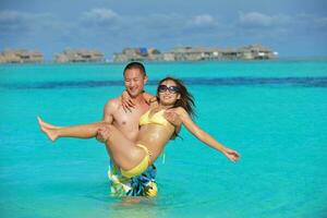 contento giovane coppia godendo estate su spiaggia foto