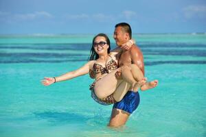 contento giovane coppia godendo estate su spiaggia foto