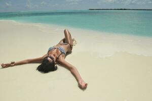 bellissimo giovane donna su spiaggia avere divertimento e rilassare foto