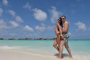 la giovane coppia felice si diverte sulla spiaggia foto