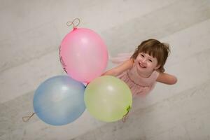 carino poco ragazza giocando con palloncini foto