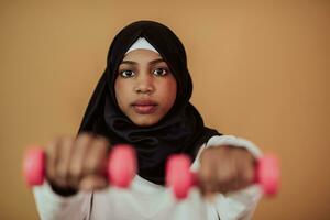 africano americano musulmano donna promuove un' salutare vita, Tenere manubri nel sua mani foto