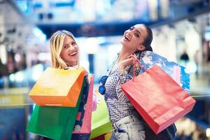 contento giovane ragazze nel shopping centro commerciale foto