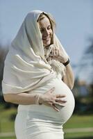 contento giovane incinta donna all'aperto foto