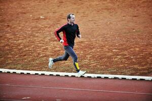 adulto uomo in esecuzione su Atletica traccia foto