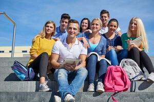 studenti al di fuori seduta su passaggi foto