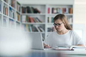 femmina alunno studia nel scuola biblioteca foto