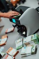 banca dipendenti utilizzando i soldi conteggio macchina mentre ordinamento e conteggio carta banconote dentro banca volta. grande importi di i soldi nel il banca foto