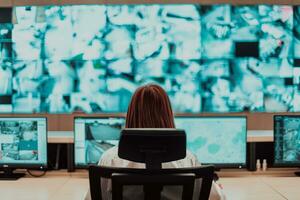 femmina sicurezza operatore Lavorando nel un' dati sistema controllo camera uffici tecnico operatore Lavorando a stazione di lavoro con multiplo mostra, sicurezza guardia Lavorando su multiplo monitor foto