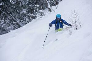 sciatore freeride che scia in discesa foto