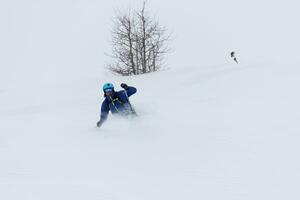 sciatore freeride che scia nella neve farinosa profonda foto