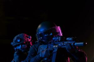 moderno guerra soldati nel buio con combattere cartucce e Armi nel il mani di attrezzata laser viste siamo nel battaglia ordine. misto media. foto