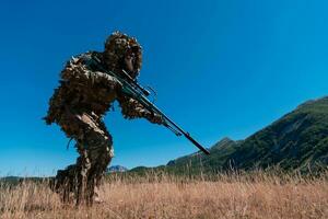 esercito soldato Tenere un' cecchino fucile con scopo e a piedi nel il foresta. guerra, esercito, tecnologia e persone concetto. foto