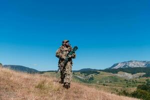 esercito soldato Tenere un' cecchino fucile con scopo e a piedi nel il foresta. guerra, esercito, tecnologia e persone concetto. foto
