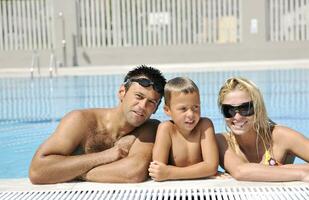 contento giovane famiglia avere divertimento su nuoto piscina foto