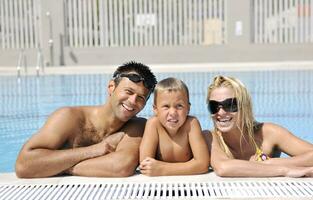 contento giovane famiglia avere divertimento su nuoto piscina foto