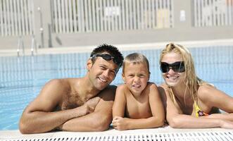 contento giovane famiglia avere divertimento su nuoto piscina foto