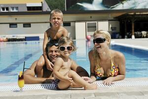 contento giovane famiglia avere divertimento su nuoto piscina foto