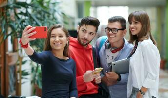 gruppo di multietnico adolescenti assunzione un' autoscatto nel scuola foto