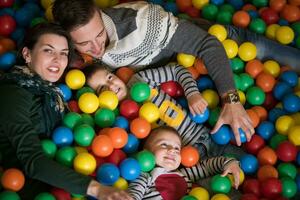 giovani genitori con bambini in una sala giochi per bambini foto