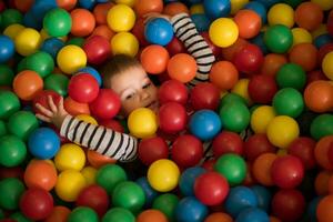 ragazzo avendo divertimento nel centinaia di colorato plastica palle foto