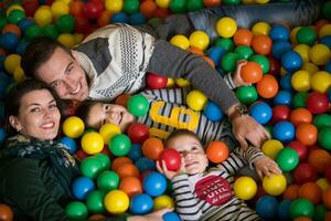 giovani genitori con bambini in una sala giochi per bambini foto