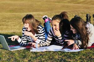 gruppo di adolescenti Lavorando su il computer portatile all'aperto foto