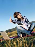 giovane ragazza adolescente lavora sul computer portatile all'aperto foto