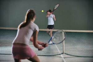 giovane ragazze giocando tennis gioco interno foto