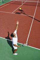 il giovane gioca a tennis all'aperto foto