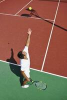 il giovane gioca a tennis all'aperto foto