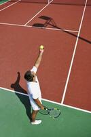 il giovane gioca a tennis all'aperto foto