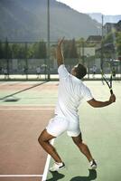 il giovane gioca a tennis foto