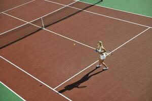 giovane donna giocare a tennis all'aperto foto