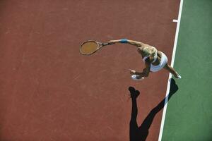 giovane donna giocare a tennis all'aperto foto