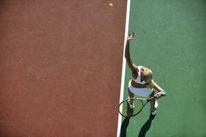 giovane donna giocare a tennis all'aperto foto