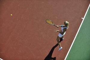 giovane donna giocare a tennis all'aperto foto